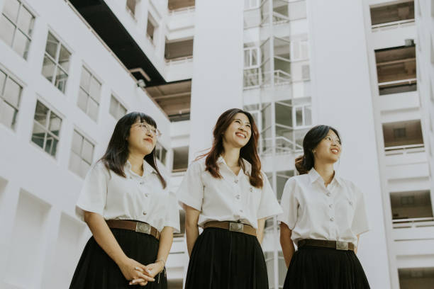 Group of Thai woman university students are walking together in their university campus.