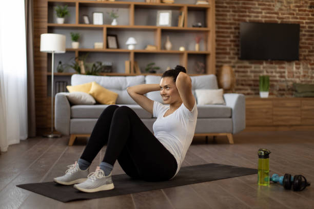 istock African woman lying on yoga mat and doing abs exercises 1476237022
