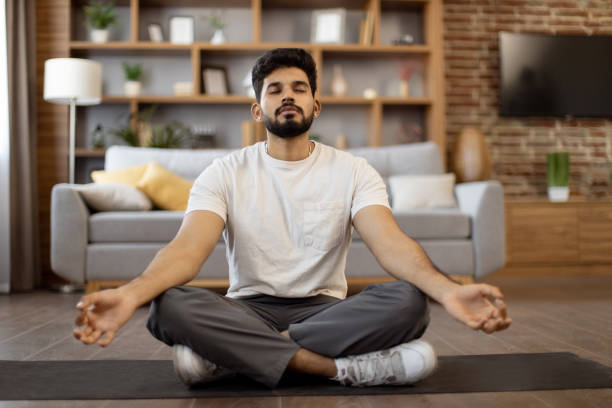 istock Indian man practicing meditation in lotus pose at home 1476237099