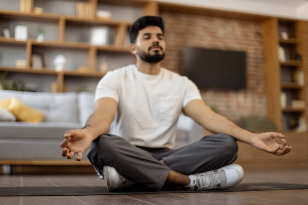istock Arabian man with closed eyes meditating on yoga mat 1476237104