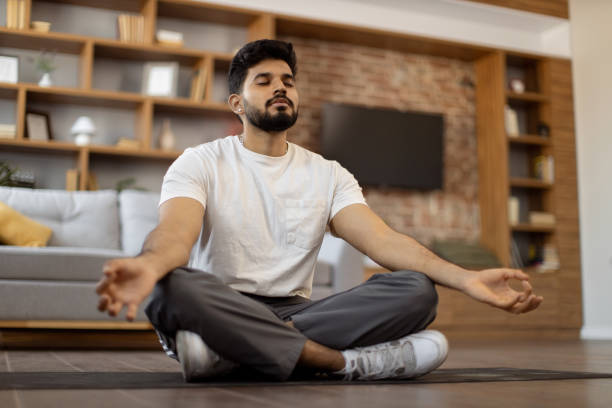 istock Arabian man with closed eyes meditating on yoga mat 1476237136
