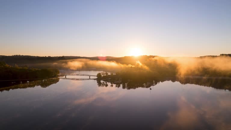 Sunrise Sunlight Drone Timelapse of St Pardoux Lake in Limousin with orange light on the fog