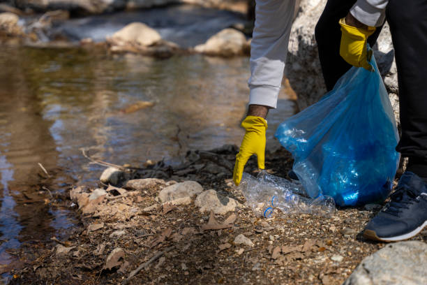 istock environmental volunteers collecting plastic waste by the river 1476238803