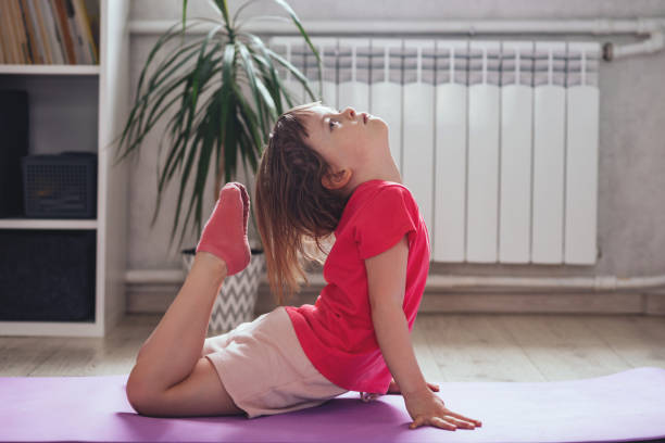 istock Child performs the exercise gymnastics at home on a mat 1476238968