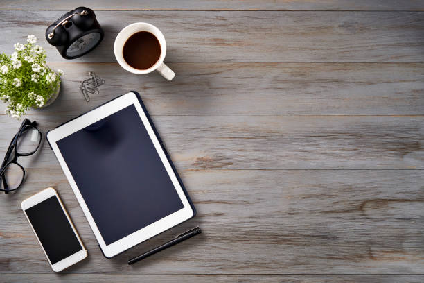 istock Top view of Notepad, smartphone, digital tablet, clock and sticky notes on a table with copy space 1476239447