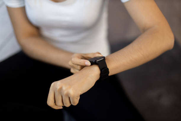 istock Sporty lady resetting fitness tracker while sitting on floor 1476239718