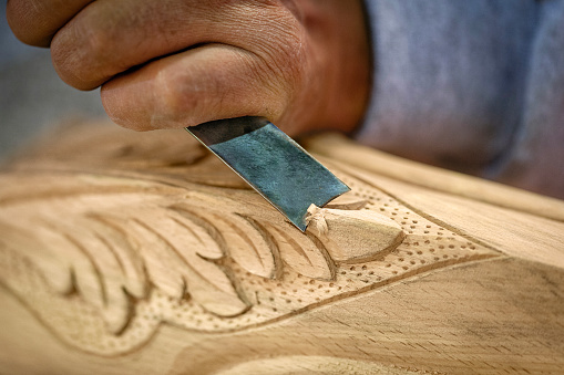 Close up of a carpenter hand working with wooden furniture.