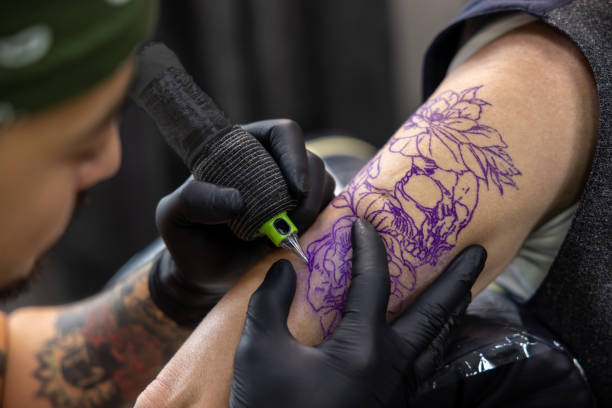 istock Male tattoo master working in the salon with a customer 1476245910