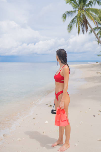 istock Young woman on white sand beach with snorkel gear 1476247252
