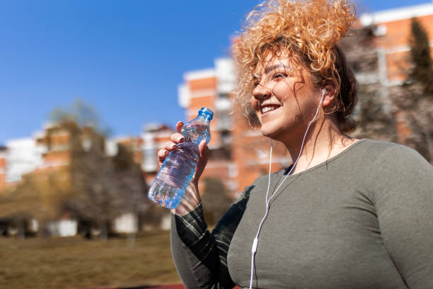 istock Young smiling overweight woman running taking a break 1476247356