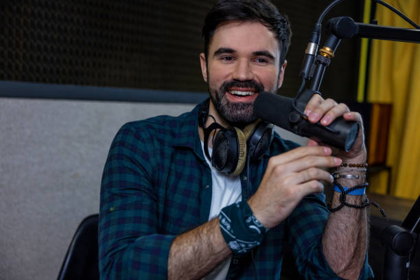istock Dark-haired young man with a microphone in hand 1476251219