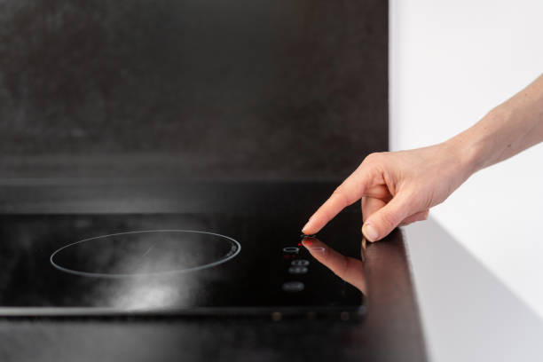 istock woman press button on electrical stove in kitchen 1476254698