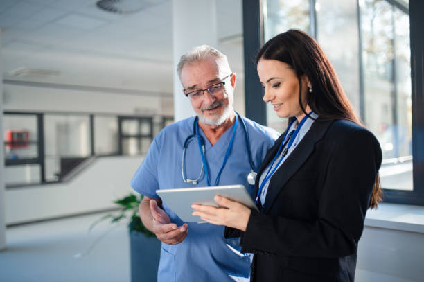 Young pharmaceutic seller explaining something to doctor in hospital. stock photo