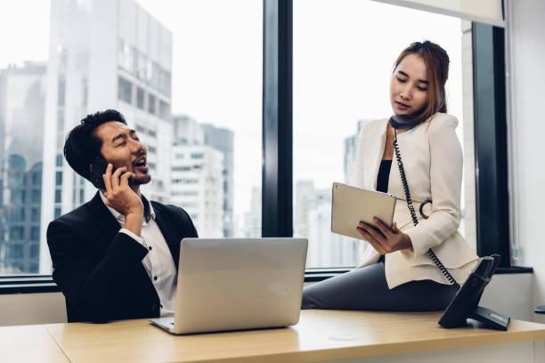 istock Call center businessman talking on headset. Call center worker accompanied by her team. Customer service executive working at office. 1476264334