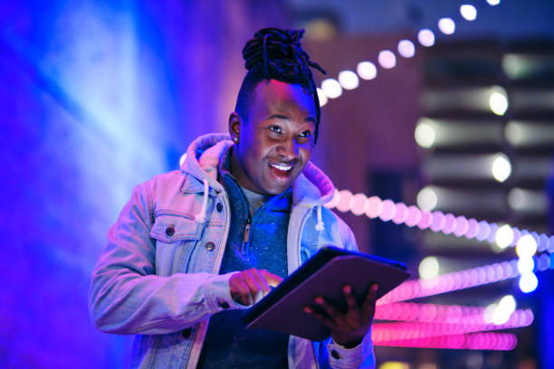 istock Young Man Using a Digital Tablet in a City at Night 1476264562