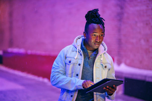istock Young Man Using a Digital Tablet in a City at Night 1476264627