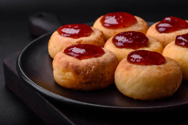 istock Delicious fresh cottage cheesecakes with raisins and vanilla on a black ceramic plate 1476266359