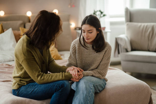 Teenage girl sharing problems with her mother. stock photo