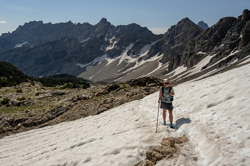 Woman Crosses Snow Patch toward Paintbrush Divide in the Tetons