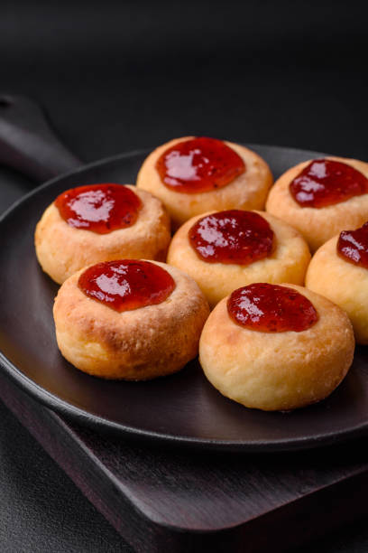 istock Delicious fresh cottage cheesecakes with raisins and vanilla on a black ceramic plate 1476266595
