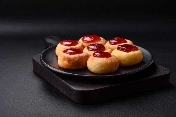istock Delicious fresh cottage cheesecakes with raisins and vanilla on a black ceramic plate 1476266599