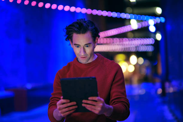 istock Young Man Using a Digital Tablet in a City at Night 1476266679