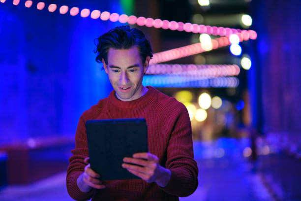 istock Young Man Using a Digital Tablet in a City at Night 1476266741