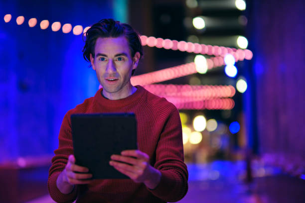 istock Young Man Using a Digital Tablet in a City at Night 1476266792