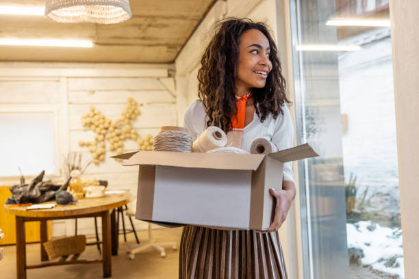istock Young curly-haired woman with a cardboard in hands 1476267541