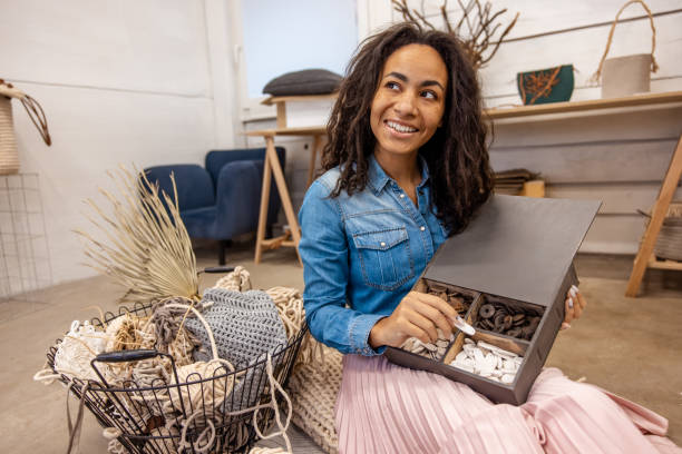 istock Smiling dark-haired woman choosing buttons from the box 1476267761