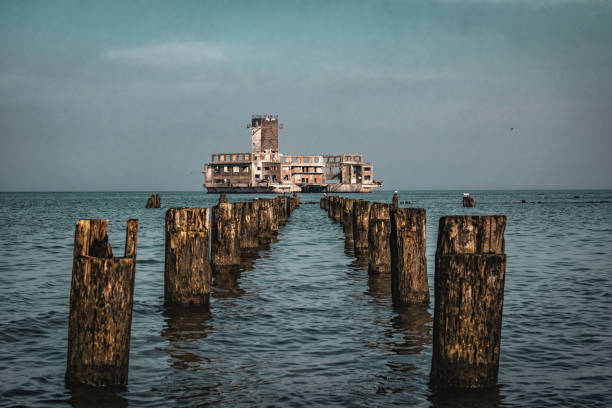 istock Old ruined wooden pier and a sandy beach 1476268542