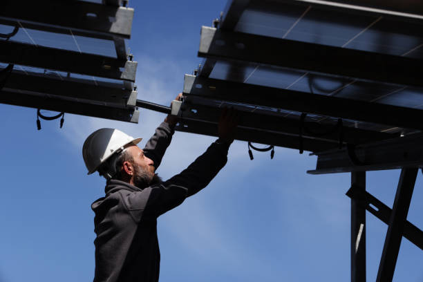 istock Male engineer installs alternative energy solar panels. 1476271324