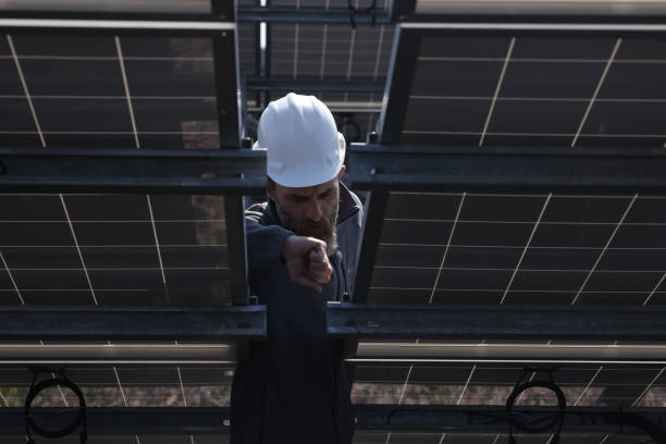 istock Male engineer installs alternative energy solar panels. 1476272534