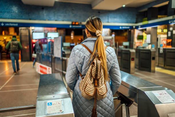 femme passant par une barrière de paiement dans une station de métro - farnes photos et images de collection