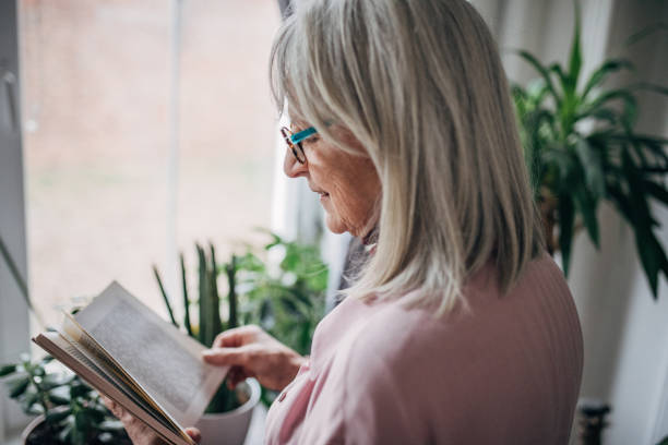 istock Senior woman reading a book 1476276058