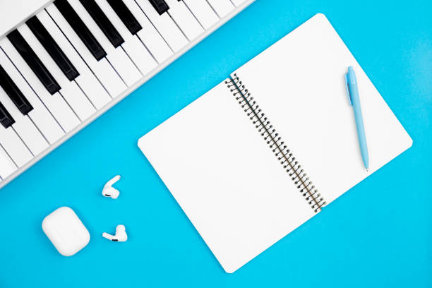 istock Blank notebook and piano on a blue background, flat lay, copy space. 1476277509