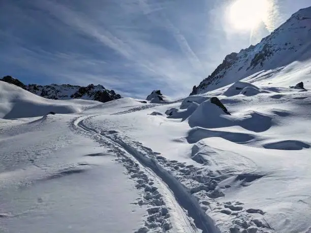 Ski touring track through the deep snow in a beautiful lonely mountain landscape. Ski tour slope. Skitouring, Skitour, Ski Tour, Skimo, Davos Klosters Monstein Switzerland. High quality photo