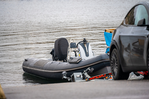 Kungsbacka, Sweden - October 23 2022: A black RIB boat ready to be loaded onto a trailer at a boat lift.