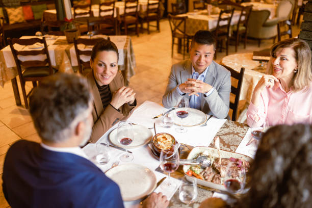 A group of coworkers gather for a sophisticated business lunch at an upscale restaurant, enjoying both the exquisite cuisine and each other's company