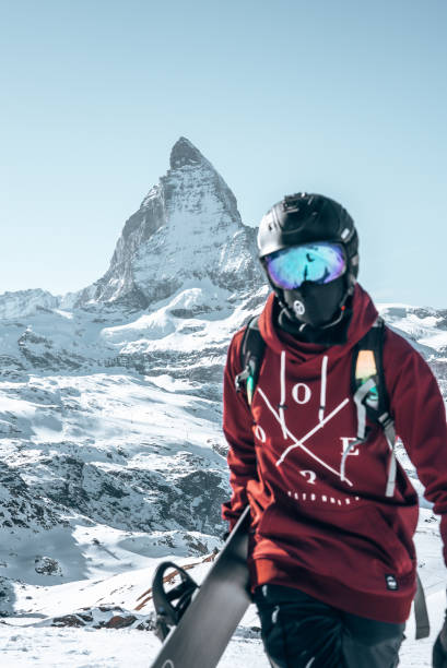 Young snowboarder spending winter holidays in Zermatt, near the famous Matterhorn peak. stock photo