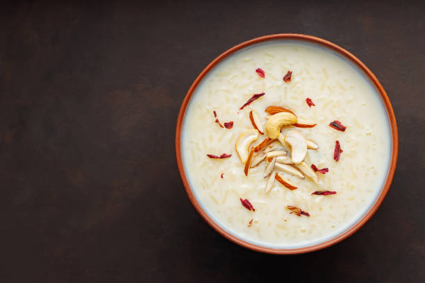 istock Bowl with rice pudding on dark background. Creamy rice kheer with cashew nuts and almonds. Copy space. Top view 1476286488