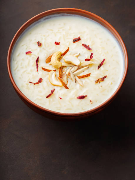 istock Bowl with rice pudding on dark background. Creamy rice kheer with cashew nuts and almonds. Copy space. Top view 1476286509