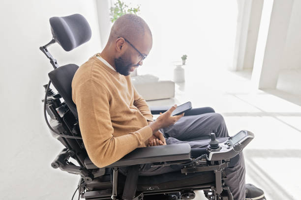 istock Disabled Black Man in a Wheelchair Using Smartphone 1476297561
