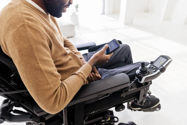 istock Disabled Black Man in a Wheelchair Using Smartphone 1476297562