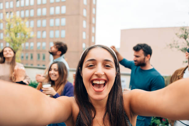 istock happy young woman taking selfie or making a video call using mobile at party - influencer streaming story on social network using phone camera 1476298113