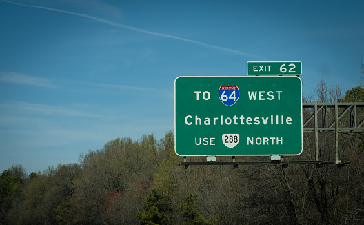 A highways sign leads drivers towards Charlottesville, VA, USA.