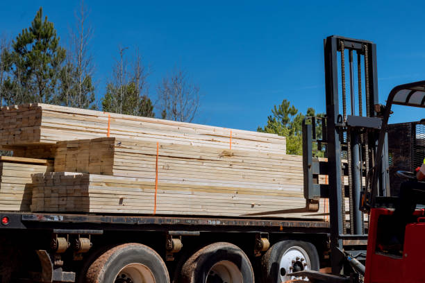 istock An unloading of wooden building materials on a construction site is performed by a lift manipulator 1476304246