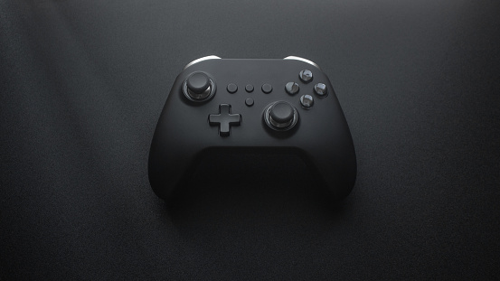 Video game controller with black color lying down on the black background. Controller in black background. Black Gamepad