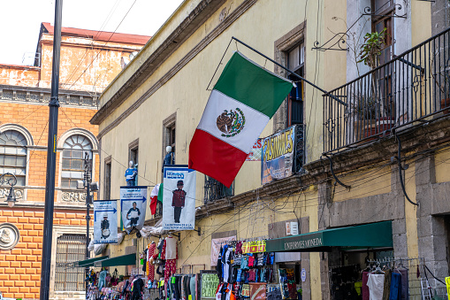 Mexico City Mexico - February 18 2022: Mexican Flag hanging outside a business in the Centro area of Mexico City