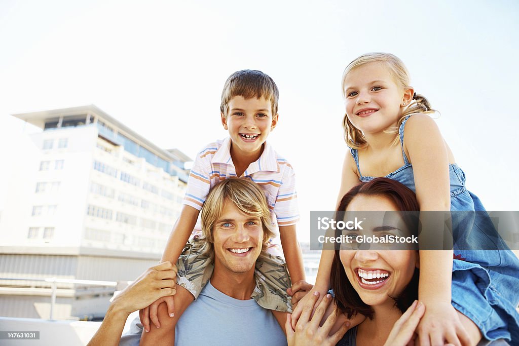 Crianças desfrutando com pais jovens passeios de ombro - Foto de stock de 20 Anos royalty-free